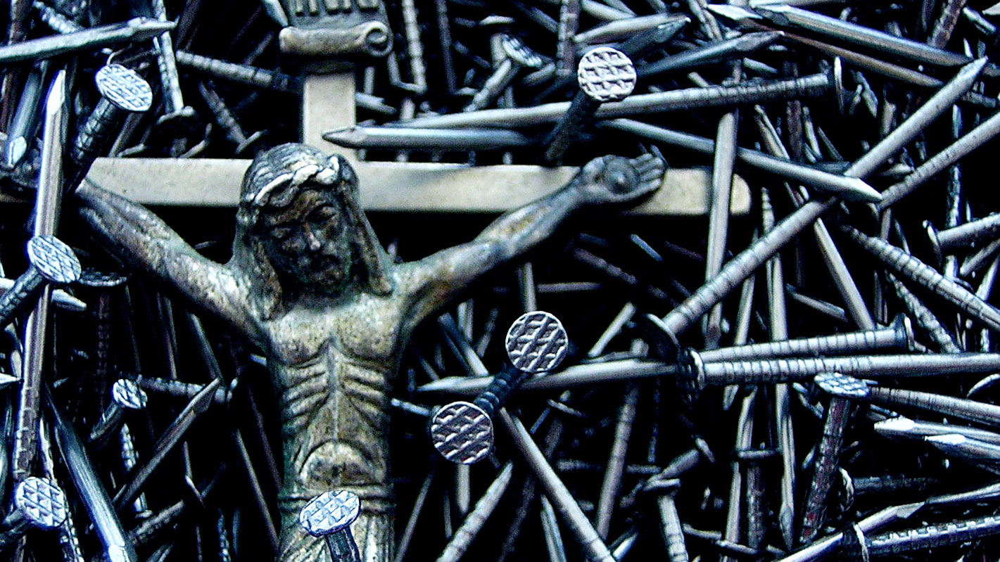 A crucifixion scene is depicted with numerous nails arranged around and through the figure of Jesus Christ.